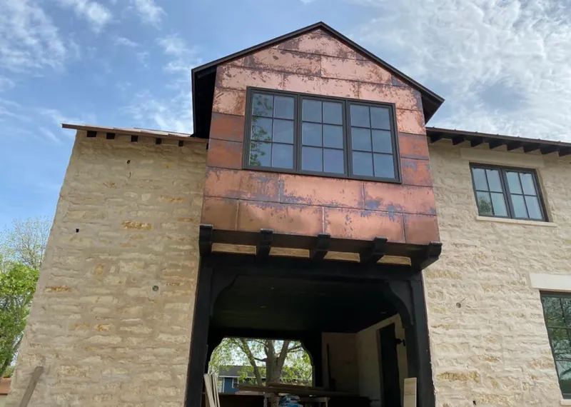 Copper metal panel facade on a stone building for Skylight Installation in Valinda
